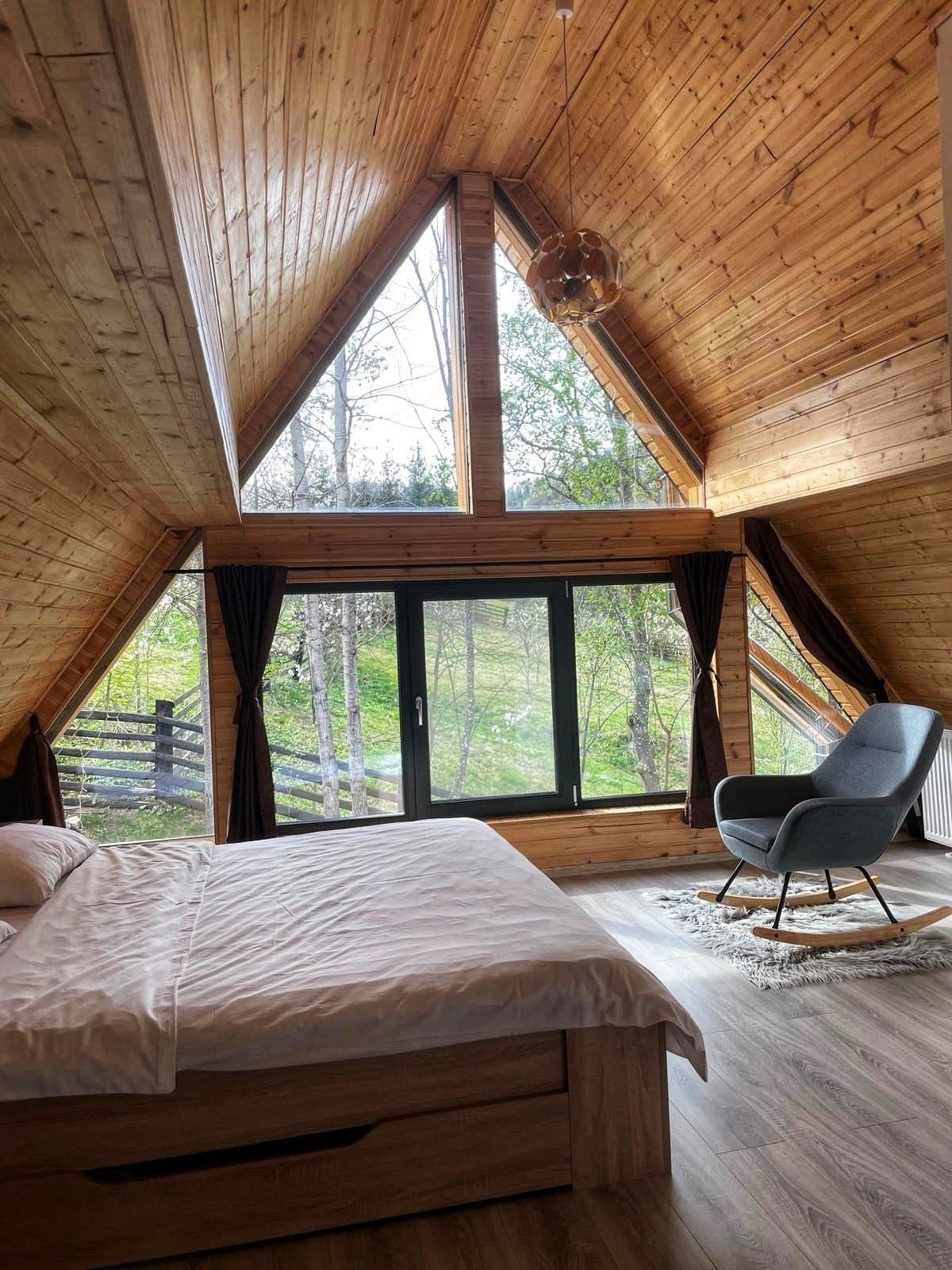 Interiorul cabanei A-Frame Green View Rarău: lemn cald și fereastră panoramică